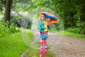 Child playing in the rain with umbrella