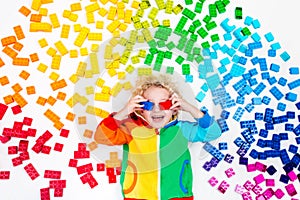 Child playing with rainbow plastic blocks toy