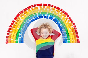 Child playing with rainbow plastic blocks toy