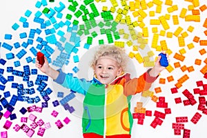 Child playing with rainbow plastic blocks toy