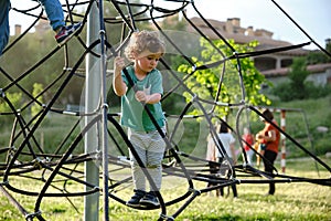 Child playing on a Rope-ladder web in a playground