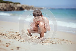 Child playing with the sand on a beach