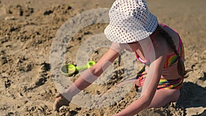 Child playing with sand on beach. Little girl at sea on summer family vacation