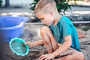 Child playing in sandbox. Happy childhood freedom creativity development, tactile Nature sensations