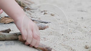 Child playing on sandpit with branches