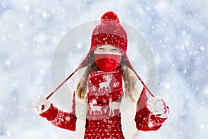 Child playing in snow on Christmas. Kids in winter