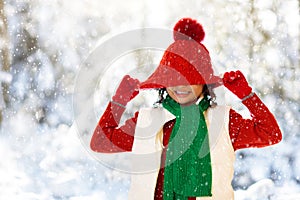 Child playing in snow on Christmas. Kids in winter