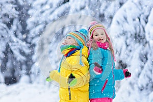 Child playing with snow in winter. Kids outdoors