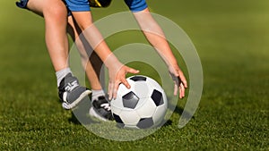 Child playing soccer. Preschool soccer leagues. Kid catching soccer ball on the field. Closeup soccer picture