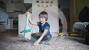 A child is playing with a soft toy a robot in the room