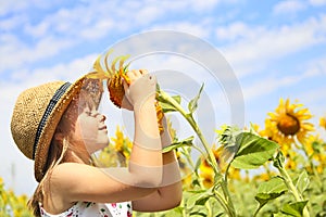 Child playing in sunflower field on sunny summer day
