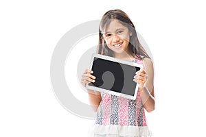 Child playing on tablet pc while standing against white background