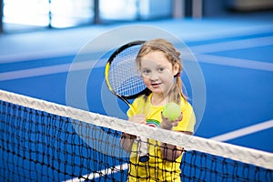 Child playing tennis on indoor court