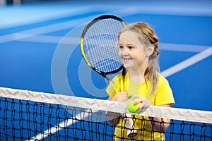 Child playing tennis on indoor court