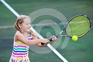 Child playing tennis on outdoor court