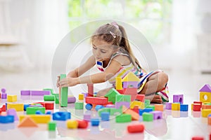 Child playing with toy blocks. Toys for kids