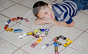 Child playing with toy cars spells out car