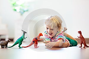 Child playing with toy dinosaurs. Kids toys