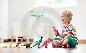 Child playing with toy dinosaurs. Kids toys