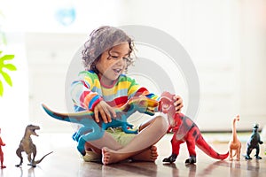 Child playing with toy dinosaurs. Kids toys