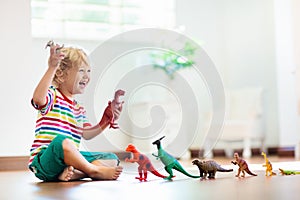 Child playing with toy dinosaurs. Kids toys