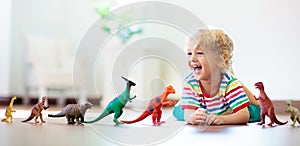 Child playing with toy dinosaurs. Kids toys photo