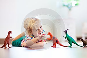 Child playing with toy dinosaurs. Kids toys