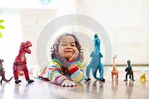 Child playing with toy dinosaurs. Kids toys