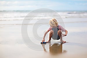 Kids play on tropical beach. Sand and water toy