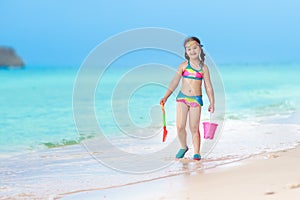 Kids play on tropical beach. Sand and water toy.