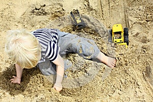 Child Playing Trucks in Sandbox