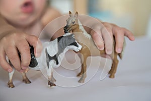 Child playing with two animal figures. The first role-playing games