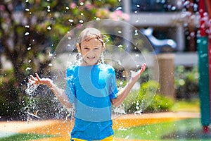 Child playing under tip bucket in water park