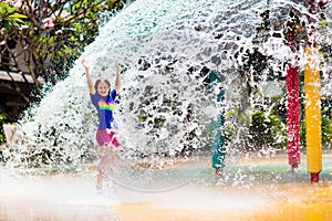 Child playing under tip bucket in water park