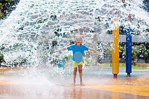 Child playing under tip bucket in water park