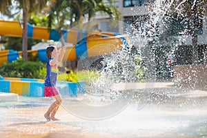 Child playing under tip bucket in water park