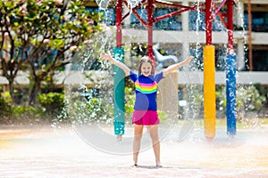 Child playing under tip bucket in water park