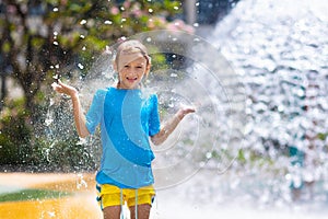 Child playing under tip bucket in water park