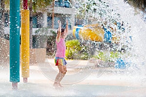 Child playing under tip bucket in water park