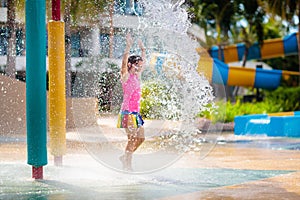 Child playing under tip bucket in water park