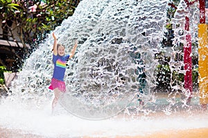 Child playing under tip bucket in water park