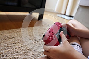 Child playing video games with controller at home, closeup. Space for text