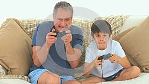 A child playing video games with his grandfather