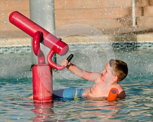 Child playing with water cannon at kiddie pool