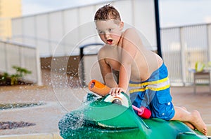 Child playing with water toy at kiddie pool