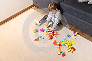 Child playing with wood blocks, at home, indoors.