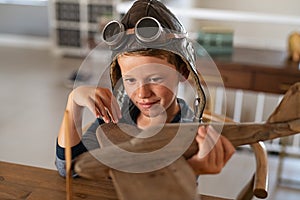 Child playing with wooden airplane at home