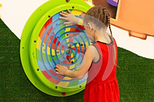 Child playing with wooden labirint in play center inside