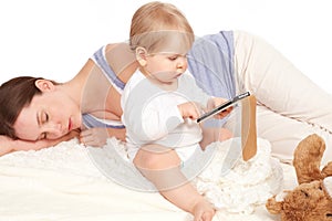 Child playing with your smartphone while mother is sleeping