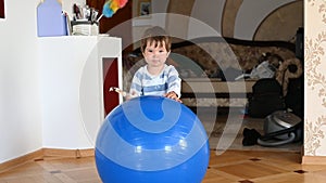 Child plays with a big blue ball